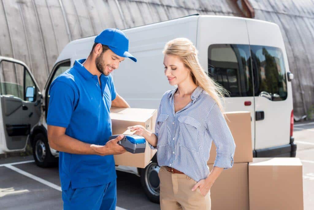 young beautiful woman paying for delivery with card